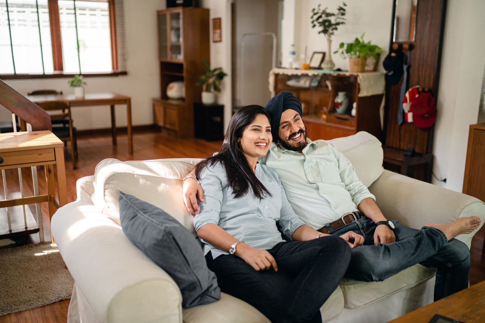 A couple relaxing together on the sofa in their living room