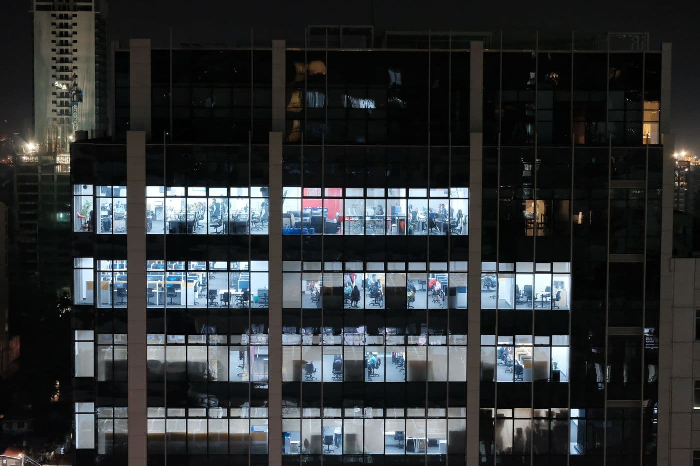 An office building at night with the lights on across every floor